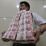 an-employee-carries-bundles-of-100-yuan-chinese-bank-notes-after-counting-at-a-bank-in-taiyuan