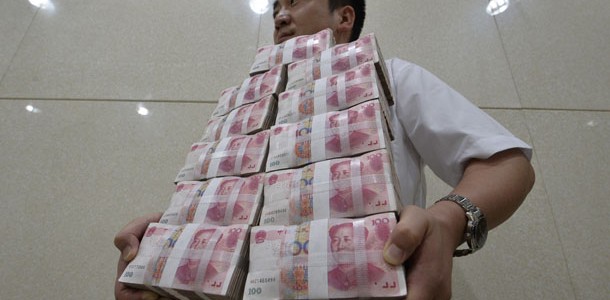 an-employee-carries-bundles-of-100-yuan-chinese-bank-notes-after-counting-at-a-bank-in-taiyuan