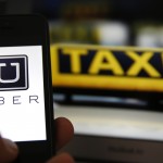 file-illustration-picture-showing-the-logo-of-car-sharing-service-app-uber-on-a-smartphone-next-to-the-picture-of-an-official-german-taxi-sign