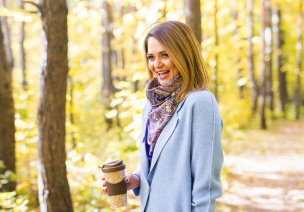 autumn-drinks-and-people-concept-woman-holding-cup-of-hot-drink