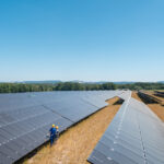 large-photovoltaic-power-plant-with-people-standing-at-the-panels