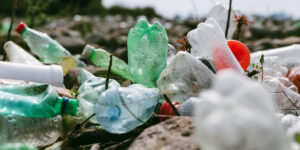 close-up-of-used-plastic-bottles-on-stone-beach-plastic-pollution-environmental-or-ecology-problem-concept